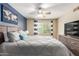 A well-lit bedroom features a ceiling fan, wood floors, an accent wall, and gray dresser at 4600 N 68Th St # 379, Scottsdale, AZ 85251