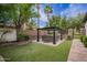 Beautiful backyard featuring a hot tub under a pergola, palm trees, and artificial grass at 4711 E Buckboard Ct, Gilbert, AZ 85297