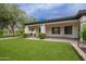 View of backyard showing covered patio, lawn, and landscaping at 4711 E Buckboard Ct, Gilbert, AZ 85297