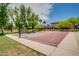 Well-maintained outdoor basketball court with mature trees and blue skies offers recreational opportunity at 4711 E Buckboard Ct, Gilbert, AZ 85297