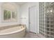 Bathroom featuring a tub, shower with glass blocks and a window with shutters at 4711 E Buckboard Ct, Gilbert, AZ 85297