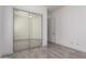 Bedroom featuring wood-style tile floors, a large mirrored closet, and an open door at 4711 E Buckboard Ct, Gilbert, AZ 85297