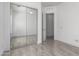 Bedroom featuring wood-style tile floors, a large mirrored closet, and an open door at 4711 E Buckboard Ct, Gilbert, AZ 85297