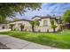 Charming single-story home features a well-manicured lawn, complemented by a decorative fence and lush landscaping at 4711 E Buckboard Ct, Gilbert, AZ 85297