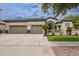Spacious home featuring a three-car garage and beautifully landscaped front yard with mature trees at 4711 E Buckboard Ct, Gilbert, AZ 85297