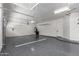 Spacious two car garage is equipped with epoxy flooring, storage racks and fan at 4711 E Buckboard Ct, Gilbert, AZ 85297