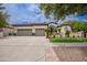 Spacious home featuring a three-car garage and beautifully landscaped front yard with mature trees at 4711 E Buckboard Ct, Gilbert, AZ 85297