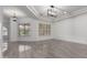Spacious room featuring tray ceilings with modern light fixtures and polished tile flooring at 4711 E Buckboard Ct, Gilbert, AZ 85297