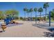 Playground featuring climbing structures, swing sets, and a slide on a sandy ground at 4711 E Buckboard Ct, Gilbert, AZ 85297