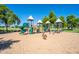 Vibrant playground equipment set in a sand-filled area, surrounded by trees and open green space at 4711 E Buckboard Ct, Gilbert, AZ 85297