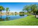 Scenic view of a pond reflecting surrounding trees and landscaping in a serene community setting at 4711 E Buckboard Ct, Gilbert, AZ 85297