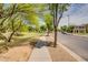 Paved sidewalk running parallel to street, lush lawn, and landscaping in residential area at 4711 E Buckboard Ct, Gilbert, AZ 85297