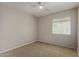 This carpeted bedroom has a ceiling fan and a window at 5320 E Silverbell Rd, San Tan Valley, AZ 85143