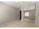 This carpeted bedroom has a mirrored closet door and a ceiling fan at 5320 E Silverbell Rd, San Tan Valley, AZ 85143