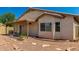 Exterior view of home featuring a covered patio, neutral stucco, well-placed windows, and desert landscaping at 5320 E Silverbell Rd, San Tan Valley, AZ 85143
