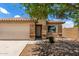 Attractive single-story home featuring a two-car garage, desert landscaping, and privacy wall at 5320 E Silverbell Rd, San Tan Valley, AZ 85143