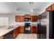 Bright kitchen showcasing stainless steel appliances, wooden cabinets, tile floors, and ample lighting at 5320 E Silverbell Rd, San Tan Valley, AZ 85143