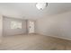 Bright, open living room with neutral carpet, a front window, and a white entry door at 5320 E Silverbell Rd, San Tan Valley, AZ 85143