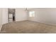 Spacious living area featuring neutral carpet and a view of the adjacent dining area and hallway at 5320 E Silverbell Rd, San Tan Valley, AZ 85143