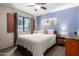 Cozy bedroom featuring a brick accent wall, large window, and neutral color scheme at 541 N Lesueur St, Mesa, AZ 85203