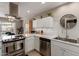 Updated kitchen with stainless steel appliances, white cabinetry, and modern backsplash at 541 N Lesueur St, Mesa, AZ 85203