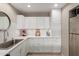 Well-lit kitchen featuring white cabinets, stainless steel appliances, and marble countertops at 541 N Lesueur St, Mesa, AZ 85203