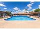 Sparkling community pool surrounded by lounge chairs and palm trees for relaxed outdoor living at 541 N Lesueur St, Mesa, AZ 85203