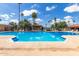 Sparkling community pool surrounded by lounge chairs and palm trees for relaxed outdoor living at 541 N Lesueur St, Mesa, AZ 85203