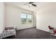 A clean, carpeted bedroom offers natural light through windows, a ceiling fan, and closet at 5519 N 187Th Ln, Litchfield Park, AZ 85340