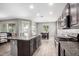 Open-concept kitchen featuring an island with a sink, granite counters, stainless appliances and seamless access to dining at 5519 N 187Th Ln, Litchfield Park, AZ 85340