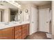 Bright bathroom features a double sink vanity with wood cabinets and neutral countertops, along with a large mirror at 5840 E Holmes Ave, Mesa, AZ 85206