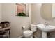 Cozy powder room with a pedestal sink, round mirror, and a plant near the window at 5840 E Holmes Ave, Mesa, AZ 85206