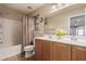 Neutral bathroom features a double sink vanity with wood cabinets and neutral countertops, along with a shower and tub at 5840 E Holmes Ave, Mesa, AZ 85206