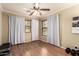 Bright bedroom featuring hardwood floors, white curtains, and modern ceiling fan at 5840 E Holmes Ave, Mesa, AZ 85206