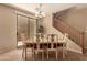 Bright dining area adjacent to a staircase, featuring a chandelier and sliding glass door access to the outdoor area at 5840 E Holmes Ave, Mesa, AZ 85206