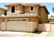 Spacious two-car garage door, enhanced by tan stucco exterior and modern lighting fixtures at 5840 E Holmes Ave, Mesa, AZ 85206