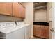 Functional laundry room with washer, dryer, storage cabinets, and a countertop space for folding at 5840 E Holmes Ave, Mesa, AZ 85206