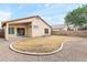 Backyard view featuring rock landscaping, covered patio area, block wall, and mature trees at 684 E Redondo Dr, Gilbert, AZ 85296