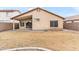 Backyard view featuring rock landscaping, covered patio area, block wall, and desert landscaping at 684 E Redondo Dr, Gilbert, AZ 85296