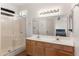 Well-lit bathroom with dual sinks, a mirrored wall, shower stall and modern fixtures at 684 E Redondo Dr, Gilbert, AZ 85296