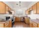 Kitchen featuring wood cabinets, tile flooring, stainless steel appliances, and plentiful counter space at 684 E Redondo Dr, Gilbert, AZ 85296