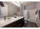 Bathroom features a double sink vanity with dark wood cabinets and tile flooring at 7432 W Bronco Trl, Peoria, AZ 85383