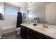 Bathroom features a double sink vanity with dark wood cabinets and tile flooring at 7432 W Bronco Trl, Peoria, AZ 85383