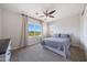 Bright bedroom features a large window with scenic views, neutral walls and carpet, and a ceiling fan at 7432 W Bronco Trl, Peoria, AZ 85383