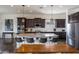 Modern kitchen boasts dark wood cabinets, a spacious island with seating, and stainless steel appliances at 7432 W Bronco Trl, Peoria, AZ 85383
