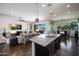 Spacious kitchen with an island and seating connects to the living and dining areas, offering views of the outdoor pool at 7432 W Bronco Trl, Peoria, AZ 85383
