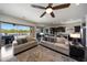 Open-concept living room with modern furnishings, ceiling fan, and sliding glass doors to the backyard at 7432 W Bronco Trl, Peoria, AZ 85383