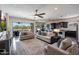 Open-concept living room with modern furnishings, ceiling fan, and sliding glass doors to the backyard at 7432 W Bronco Trl, Peoria, AZ 85383