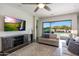 Open-concept living room with TV and sliding glass doors providing access to the backyard at 7432 W Bronco Trl, Peoria, AZ 85383