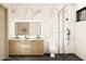 Modern bathroom featuring a double vanity, marble tile, and a glass-enclosed shower with black fixtures at 7445 E Vista Dr, Scottsdale, AZ 85250